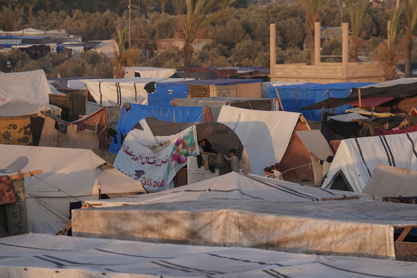 Palestinians displaced, by the Israeli air and ground offensive on the Gaza Strip, stand in...