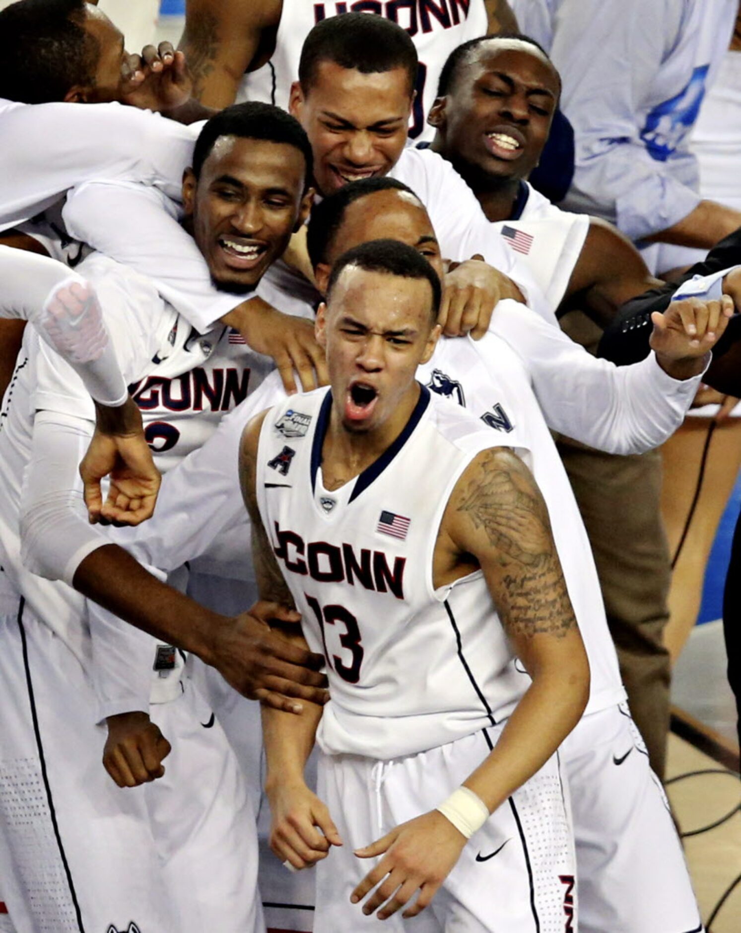 Connecticut Huskies guard Shabazz Napier (13) and other teammates celebrate their 60-54 win...