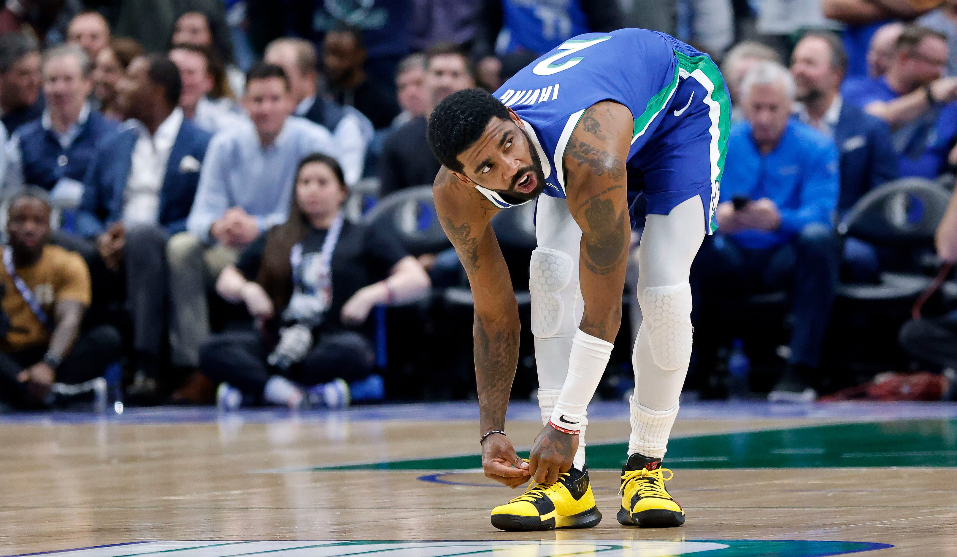 Dallas Mavericks guard Kyrie Irving (2) laces up his shoes before tipoff against the...