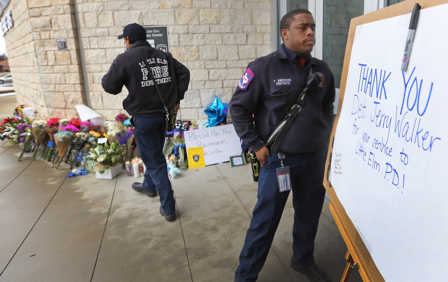 Little Elm firefighters Xavier Alonzo (left) and Terry Anderson help put up a placard to be...