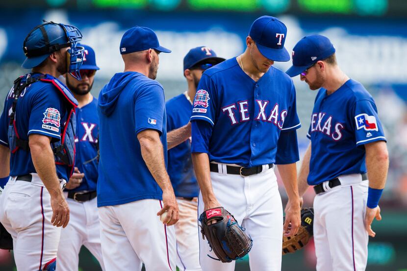 Texas Rangers starting pitcher Brett Martin (59) is taken off the mound during the first...