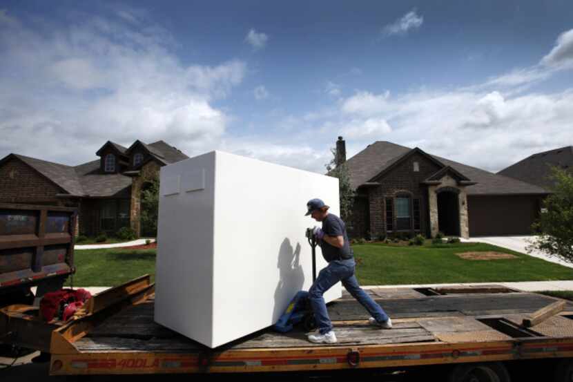 David McColm with Tornado Masters prepares to unload an above-ground tornado shelter at the...