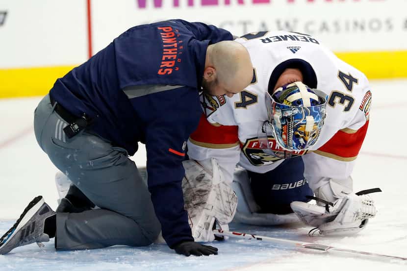 Florida Panthers staff help goaltender James Reimer after Reimer suffered an apparent injury...