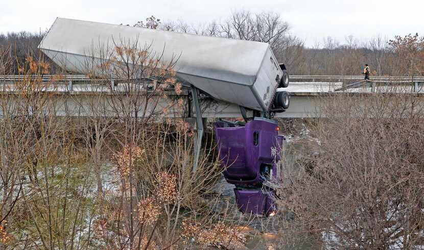 The cab of a semi truck  dangled over a bridge on the northbound side of Interstate 45 near...