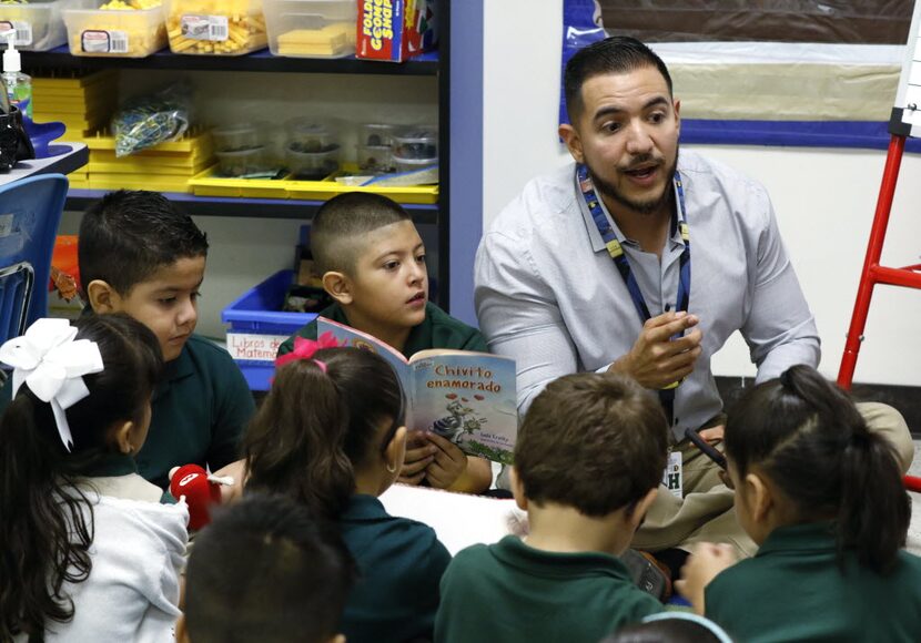 First graders Fernando Gonzalez, 6, left, and Daniel Mendez, 6, center, take part in a...