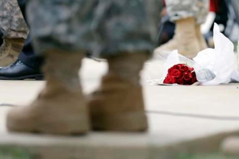 
Roses left for shooting victims lay at the feet of Lt. Gen. Mark Milley, U.S. Sen. John...