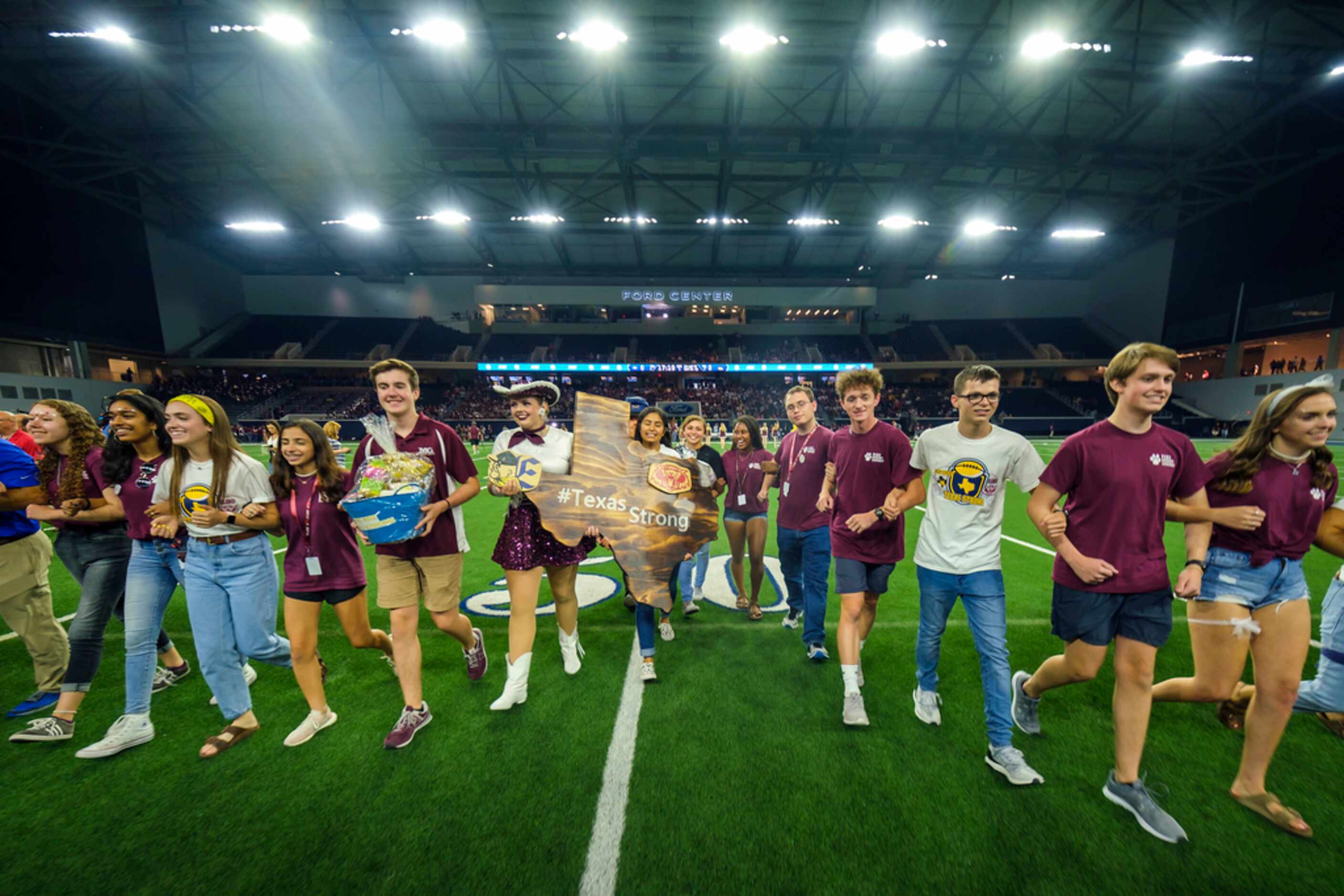 Student government representatives from Plano and El Paso Eastwood High Schools lock arms as...