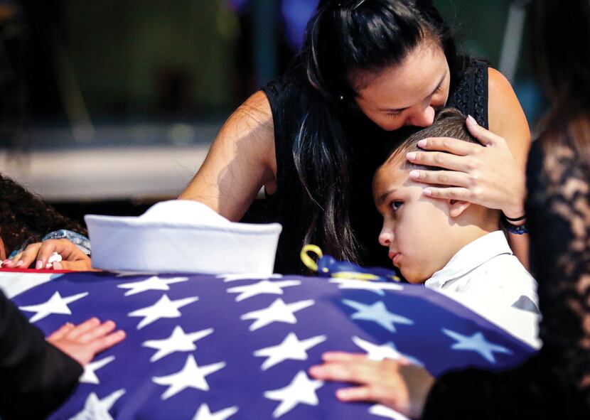 Kristy Villasenor, partner of Dallas police Officer Patrick Zamarripa, comforted her son,...
