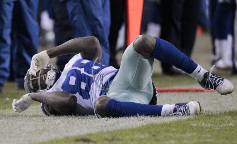 Dallas Cowboys wide receiver Dez Bryant (88) rolls on the ground after a pass was defended...