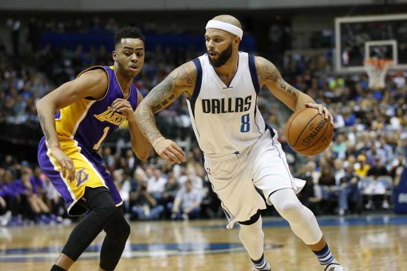 Dallas Mavericks guard Deron Williams (8) drives towards the basket as he is defended by Los...