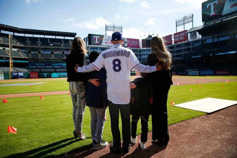 Texas Rangers' new manager Chris Woodward poses for a photo with his family after a press...