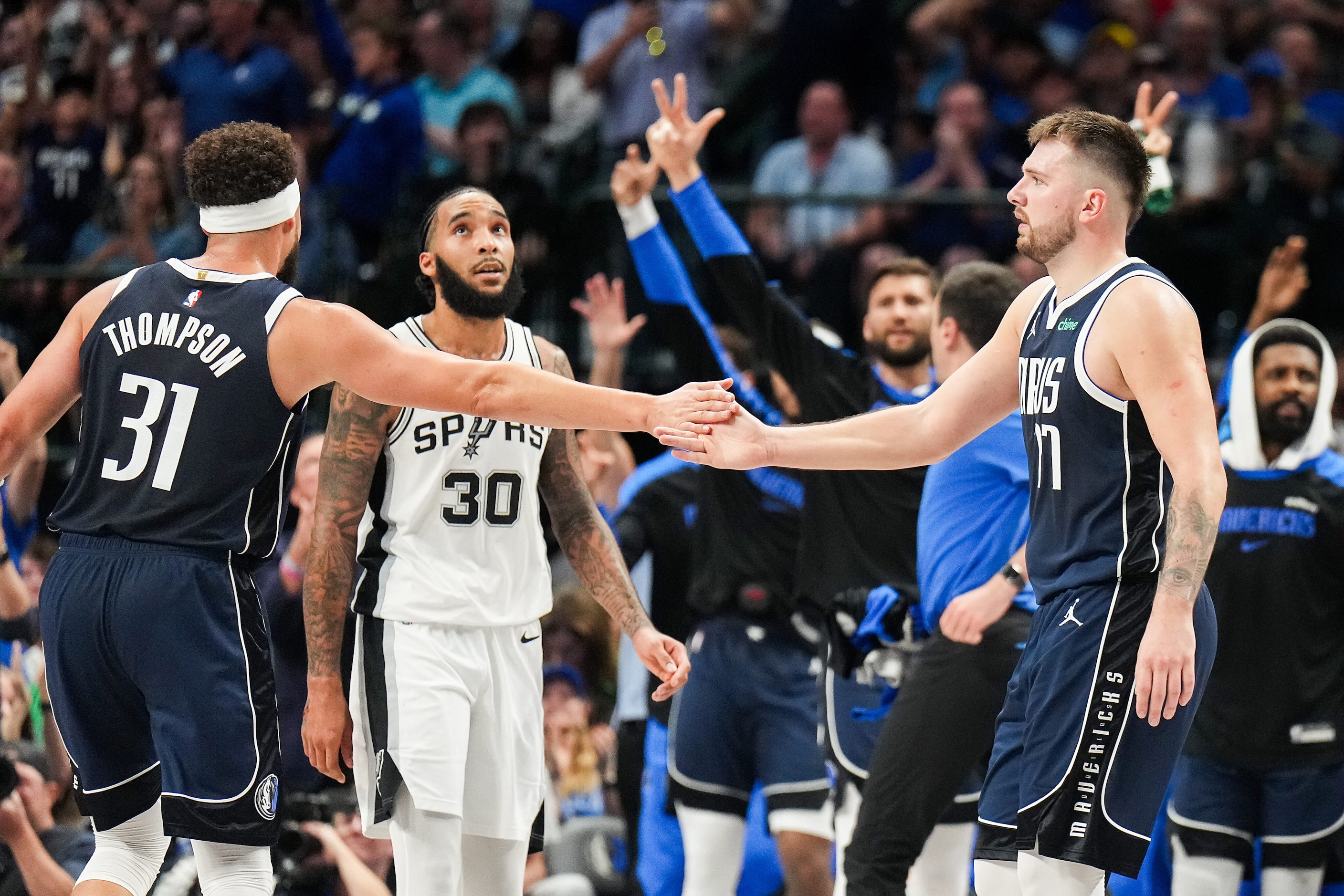 Dallas Mavericks guard Klay Thompson (31) gets a hand from guard Luka Doncic (77) after a...