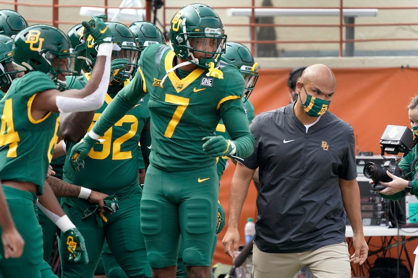 Baylor head coach Dave Aranda, right, leads his team onto the field before an NCAA college...