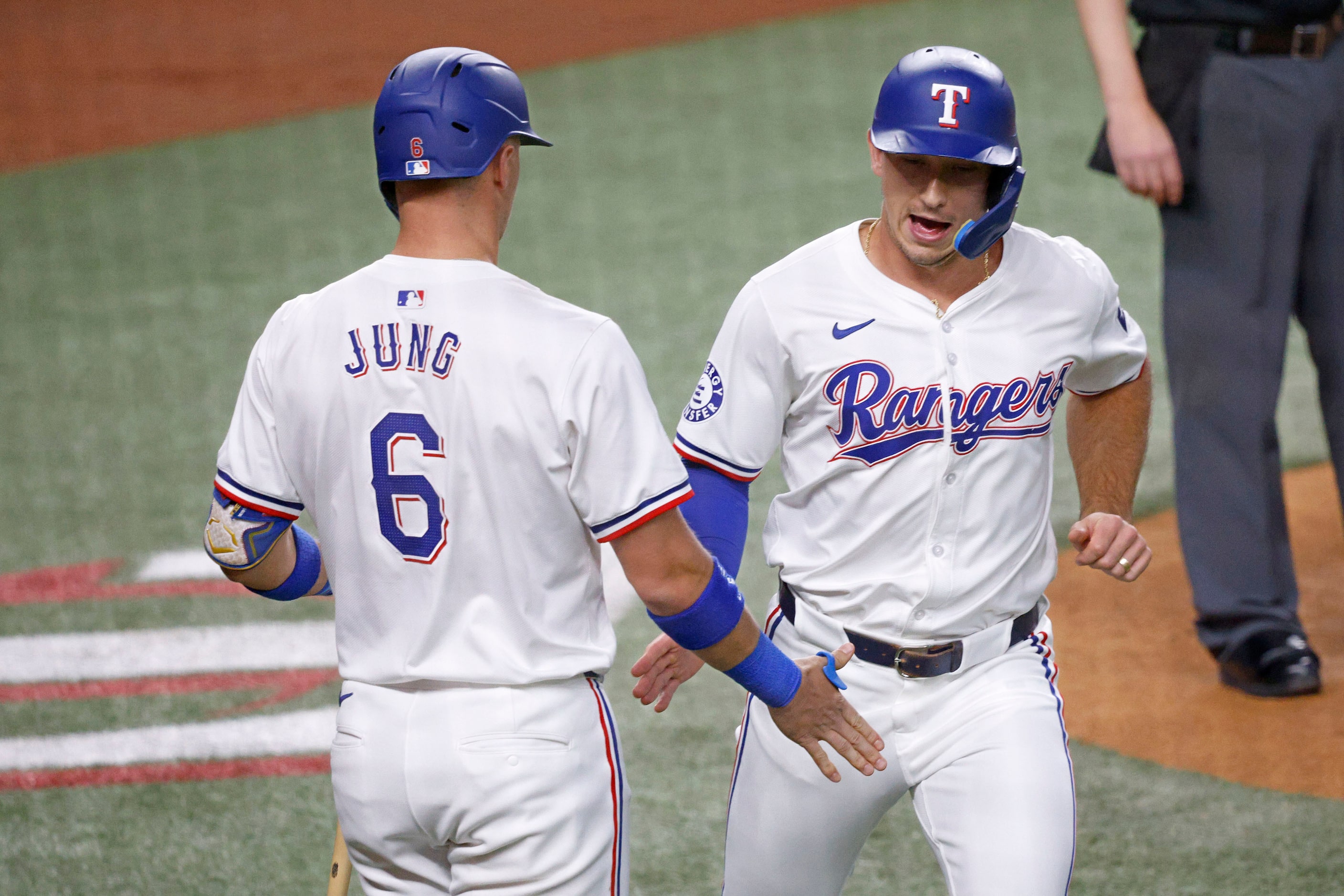 Texas Rangers outfielder Wyatt Langford (36) gets a high-five from his teammate Josh Jung...