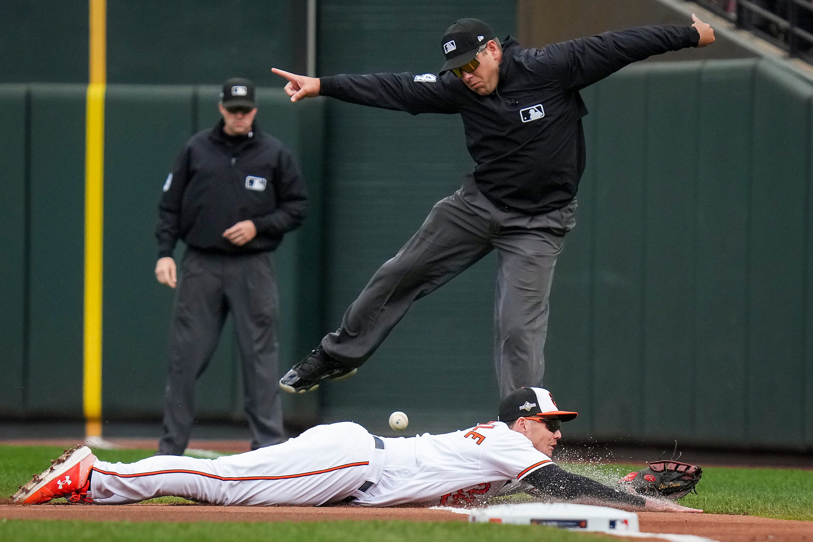 First base umpire John Libka leaps out of the way as Baltimore Orioles first baseman Ryan...