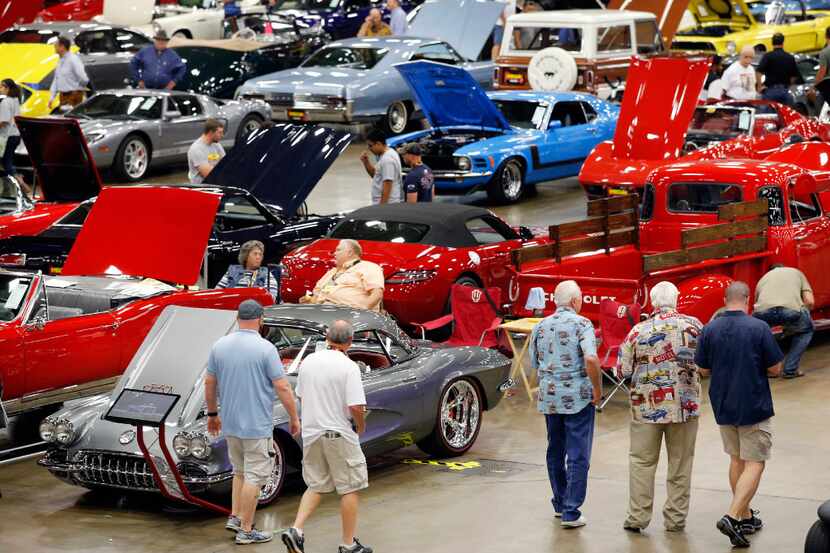 Car and truck enthusiasts walk the auction floor during the Mecum  Auto Auction show and...