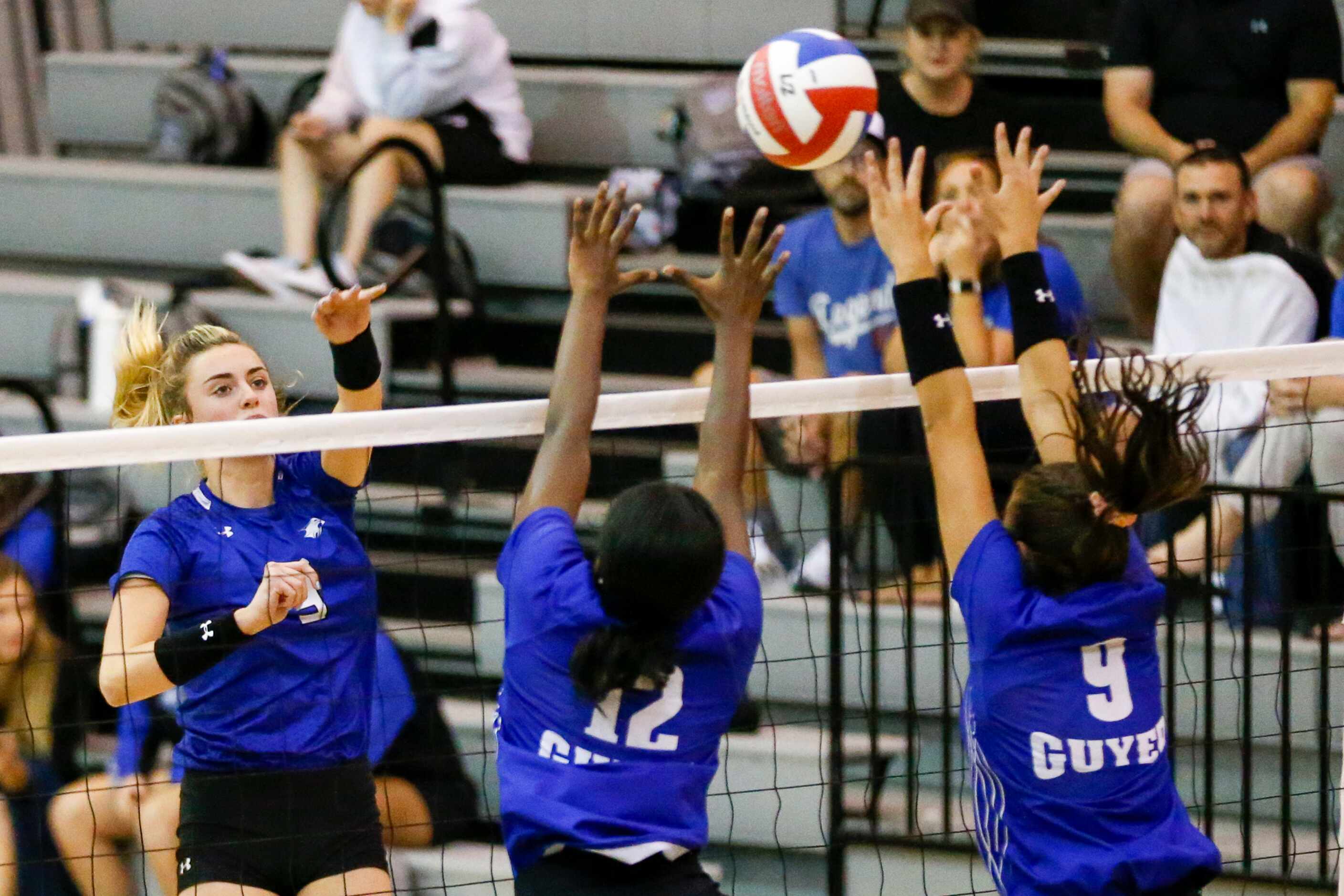 Trophy Club Byron Nelson outside hitter Sam Hoppes (9) spikes the ball past Denton Guyer...