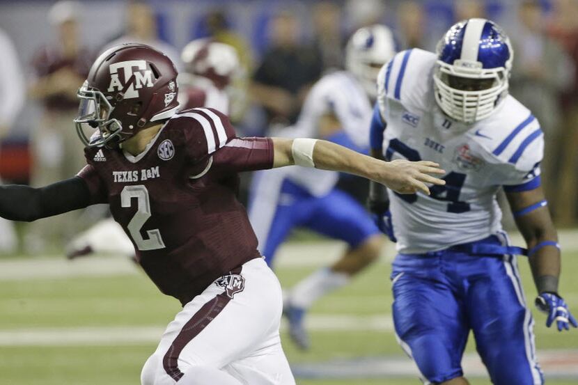 Texas A&M quarterback Johnny Manziel (2) is chased by Duke linebacker C.J. France (54) in...