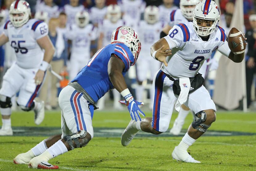 Louisiana Tech Bulldogs quarterback J'Mar Smith (8) attempts to avoid a tackle by Southern...