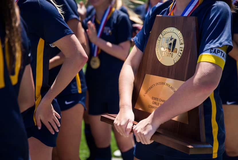 A Highland Park player holds the state championship plaque after her team won the UIL...
