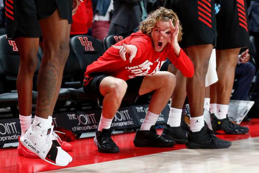 Houston Cougars guard Landon Goesling (2) celebrates on the bench after a three point shot...