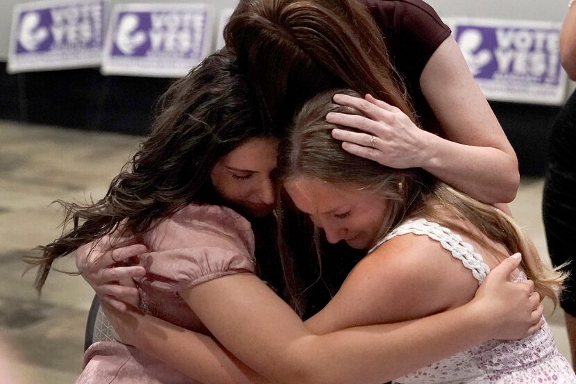 Hannah Joerger, left, Amanda Grosserode, center, and Mara Loughman hug after a Value Them...