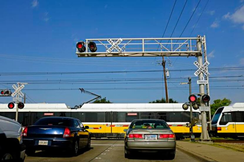 
Cars wait at the Park Boulevard crossing for a southbound DART train to pass in Plano. One...
