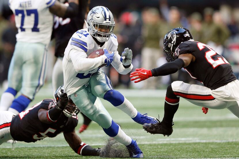 Dallas Cowboys running back Ezekiel Elliott (21) shakes defenders Atlanta Falcons linebacker...