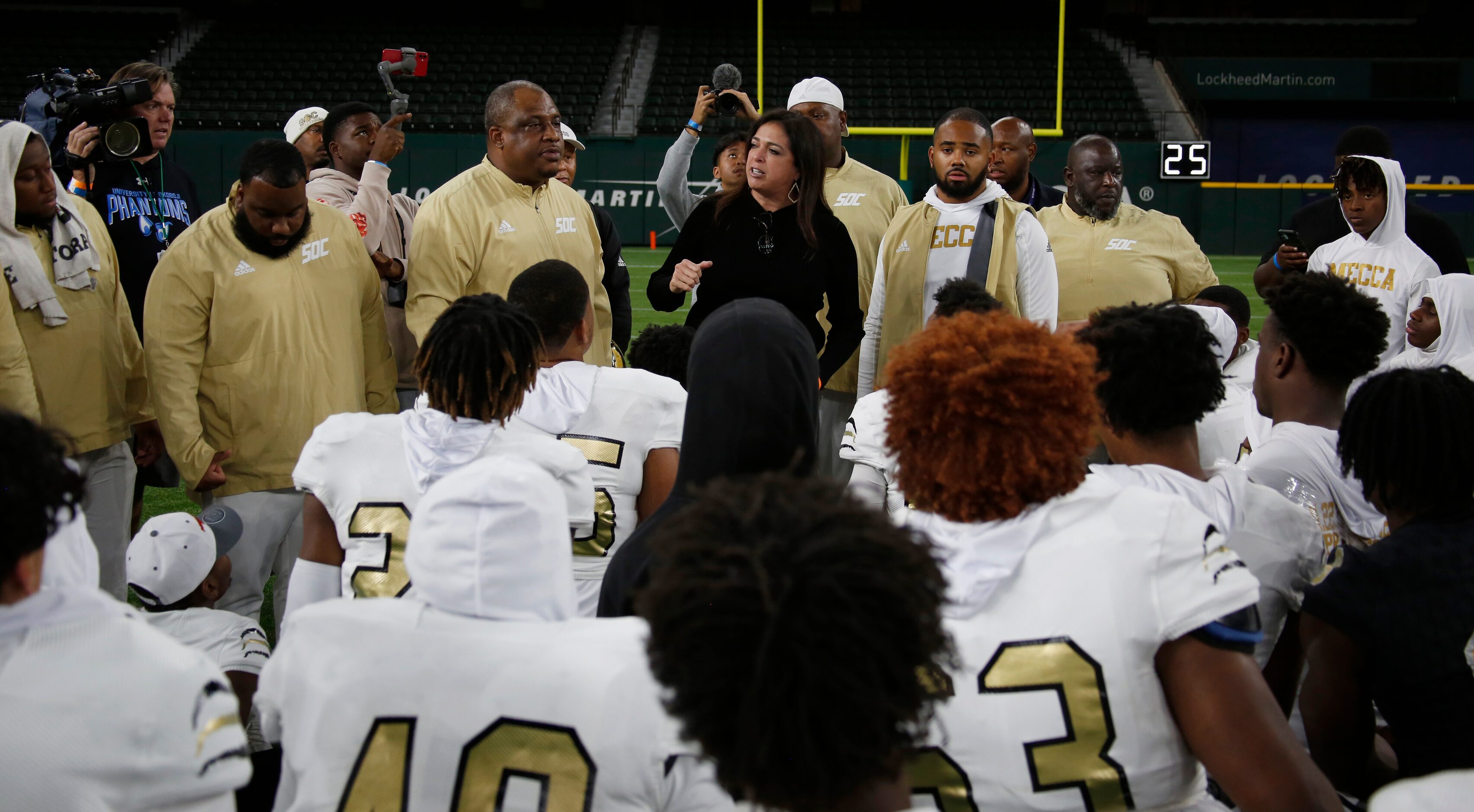 Dallas ISD Athletic Director Dr. Sylvia Salinas, center, delivers an inspirational post-game...