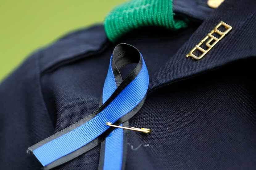 A Dallas Police officer wore a blue ribbon during the Tribute 7/7 memorial event at Dallas...