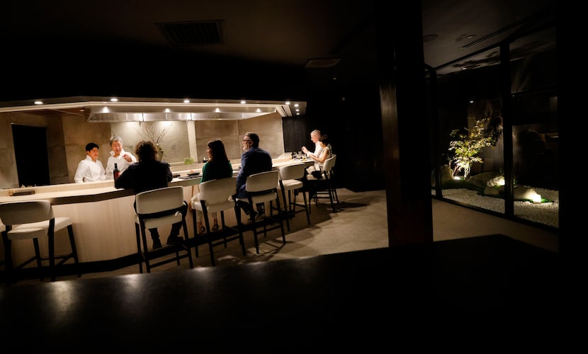 Chef Masayuki Otaka, second from left, talks to his customers at his new Japanese restaurant...