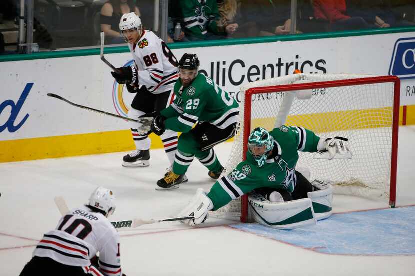 Dallas Stars goalie Ben Bishop (30) reaches for the puck as Chicago Blackhawks right wing...