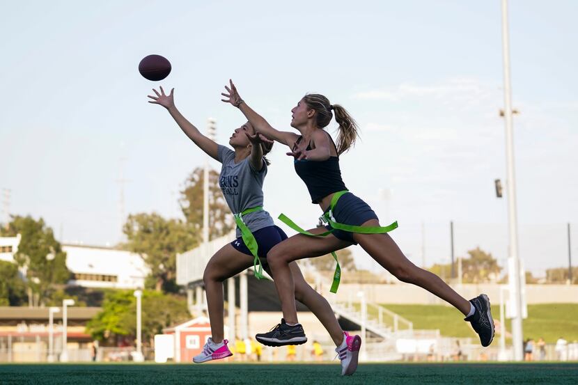 Syndel Murillo, 16, left, and Shale Harris, 15, reach for a pass as they try out for the...