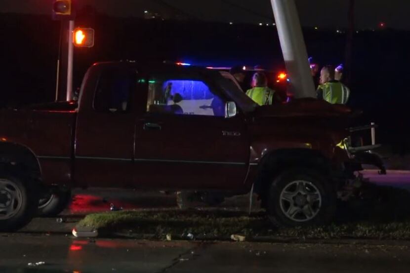 Fort Worth police examine the wreckage of a truck that hit a traffic light pole Wednesday...