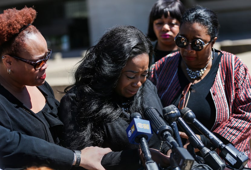 Supporters surround Keyaira Saunders as she speaks during a news conference at Dallas City...