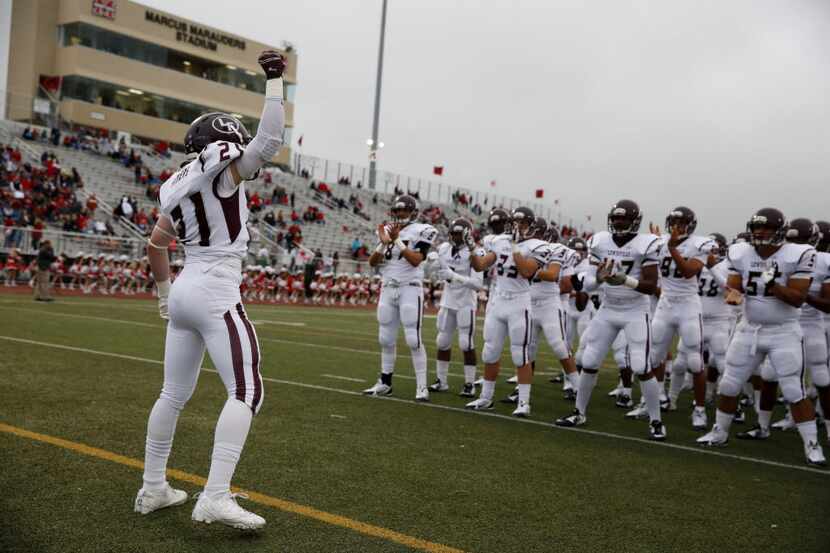 Lewisville defensive back Kori Williams (21) gets his team ready before a high school...
