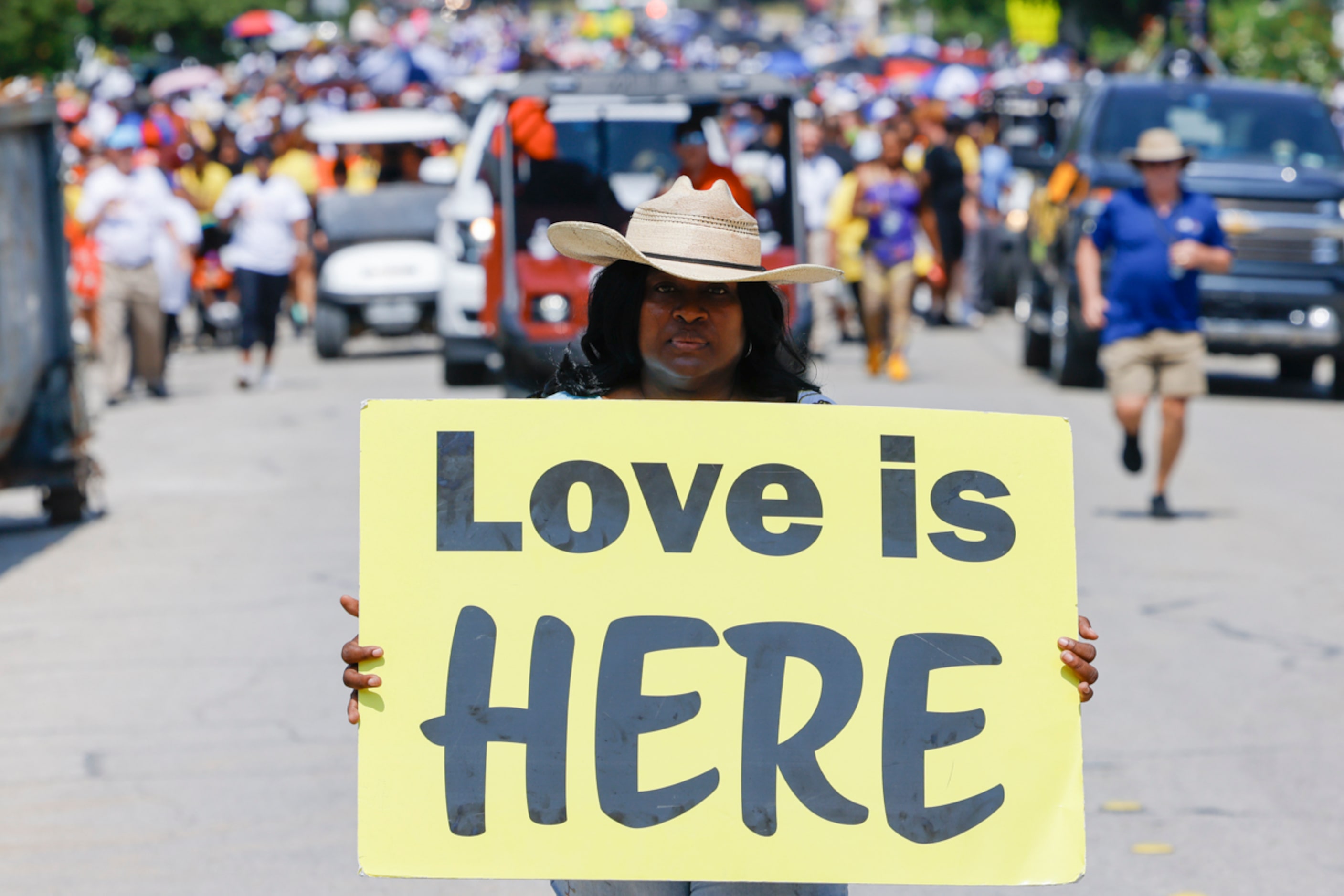 An attendee marches holding a sign ahead of the crowd during Opal's Walk for Freedomon...