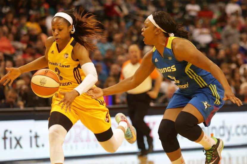 Indiana Fever's Tiffany Mitchell, left, gains possession of a ball knocked loose from Dallas...