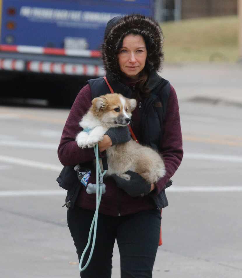 Jessica Treiber carries her new puppy, Jabba the Mutt, during a walk along Malcolm X...