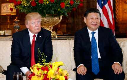 President Donald Trump and Chinese President Xi Jinping, sit as they pose for photographers...