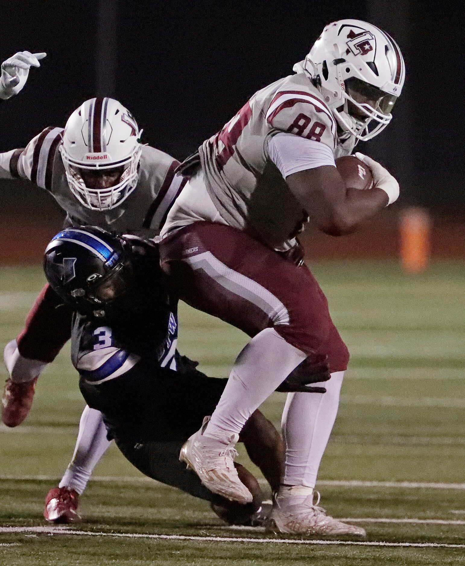 Lewisville High School running back Xavier Fleming (88) drags Hebron High School defensive...