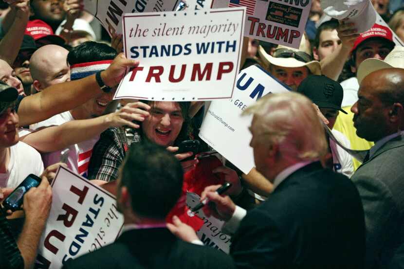 Fans crowded around Donald Trump as he signed autographs during a campaign rally at Gilley's...