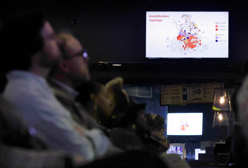 People listen to a panel discussion at Gilley’s Southside Music Hall in Dallas as maps...