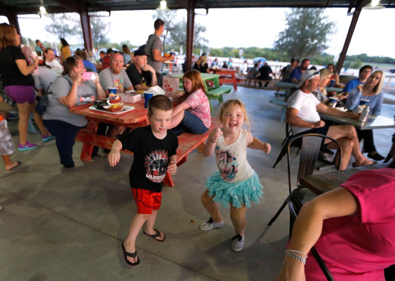 Jayden, left, and  Meike Sharpe dance to the tunes played by musician Joshua Irwin on the...