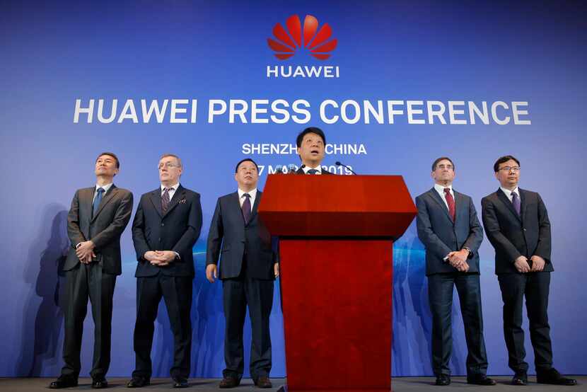 Huawei Rotating Chairman Guo Ping, center, speaks in front of other executives during a...