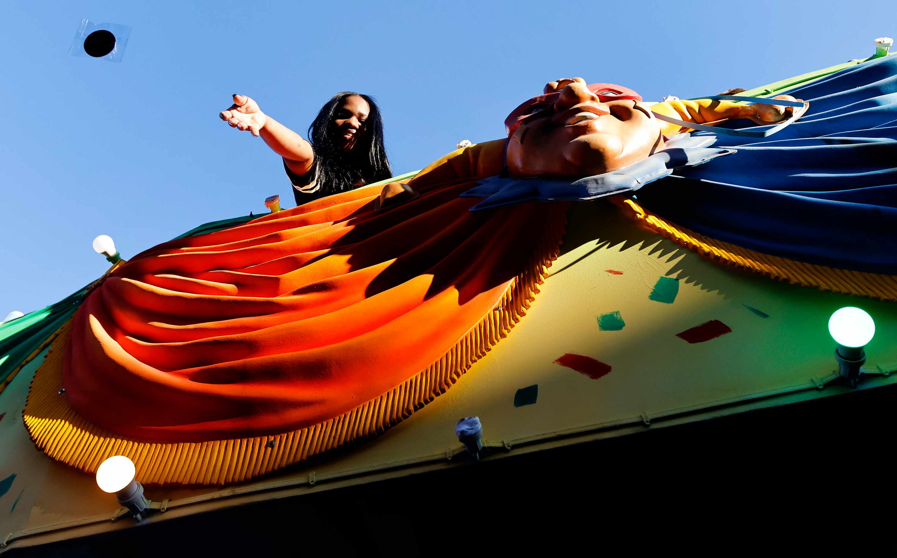 A woman tosses team buttons from a float during the Mardi Gras-style Allstate Sugar Bowl New...