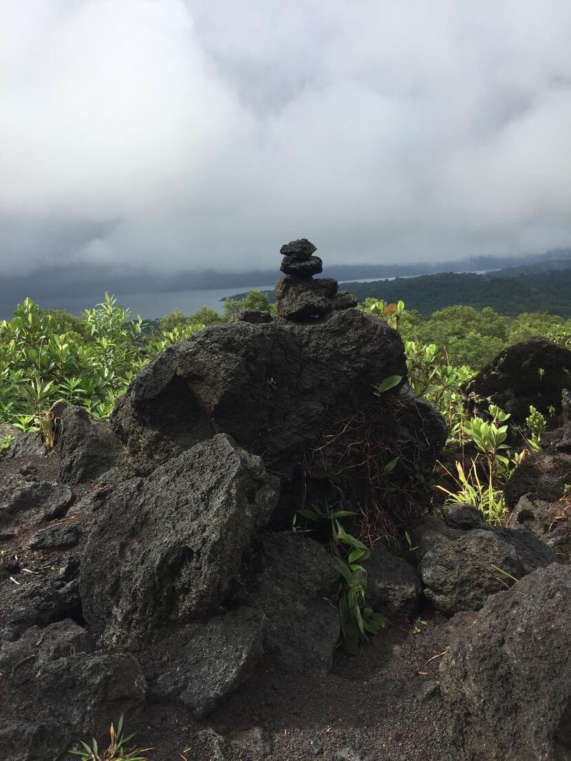 Lava formation on volcano hike with view of Lake Arenal
