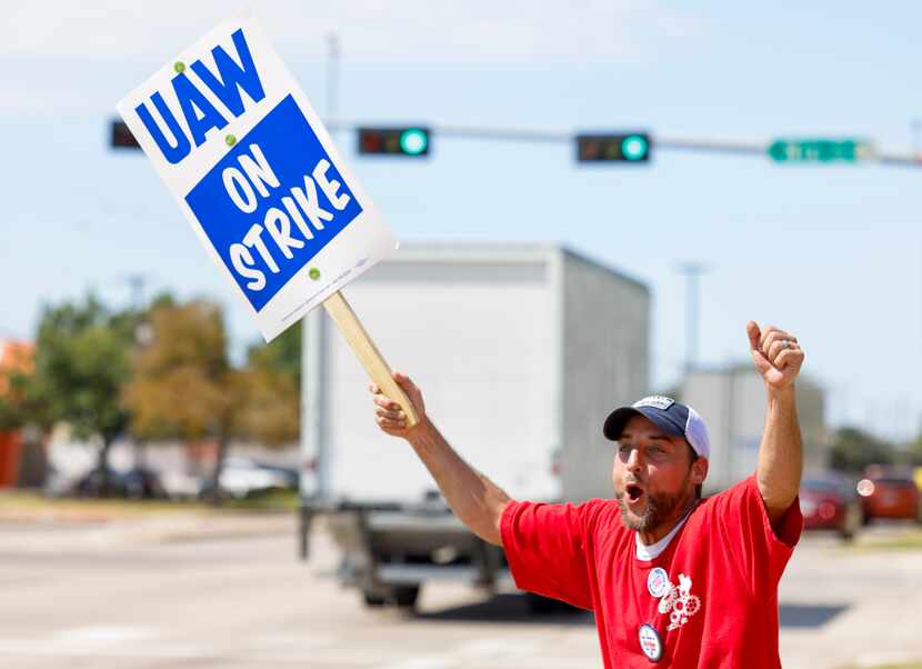 Phillip Laws raises his arms and yells Friday to draw attention to United Auto Workers...