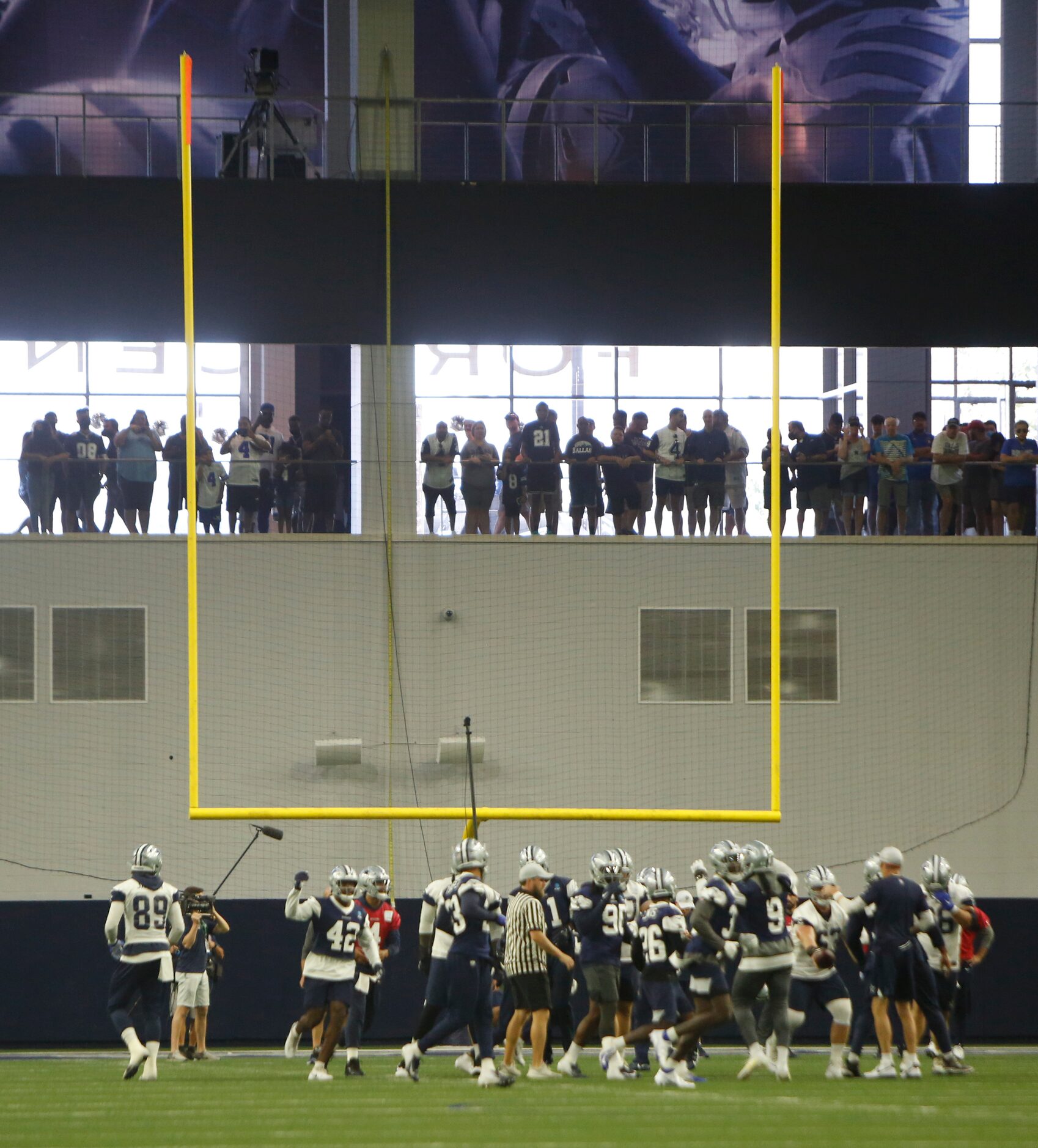 Dallas Cowboys fans oversee a team practice session from the foyer of the Ford Center. The...