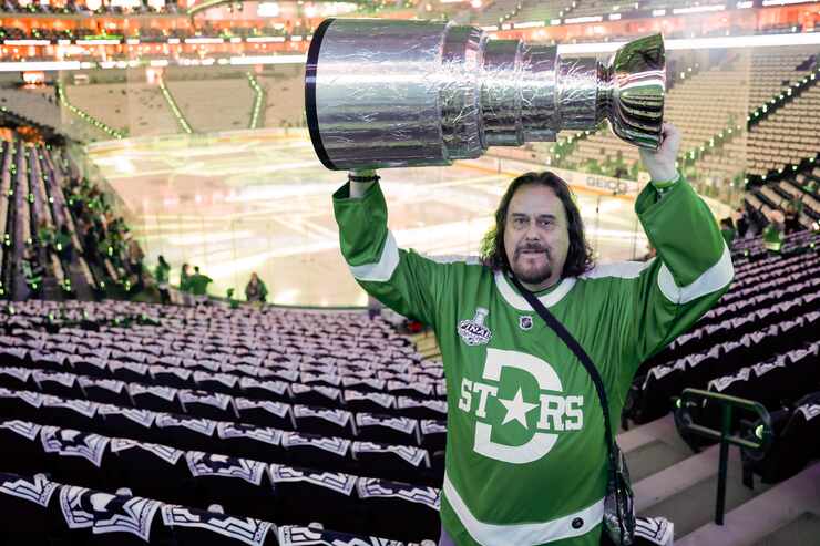 Dallas Stars fan Brad Little of Bedford hoists his homemade Stanley Cup replica before Game...